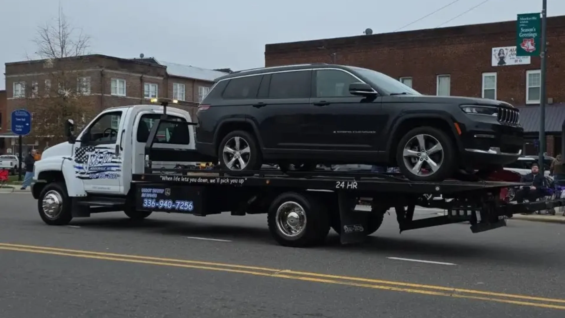 Joe’s Tow rollback transporting a black SUV through Mocksville